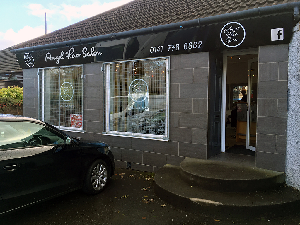 hair salon with new gloss black sign tray with white cut out lettering and tinted glass hanging plaques with with vinyl hangin in window